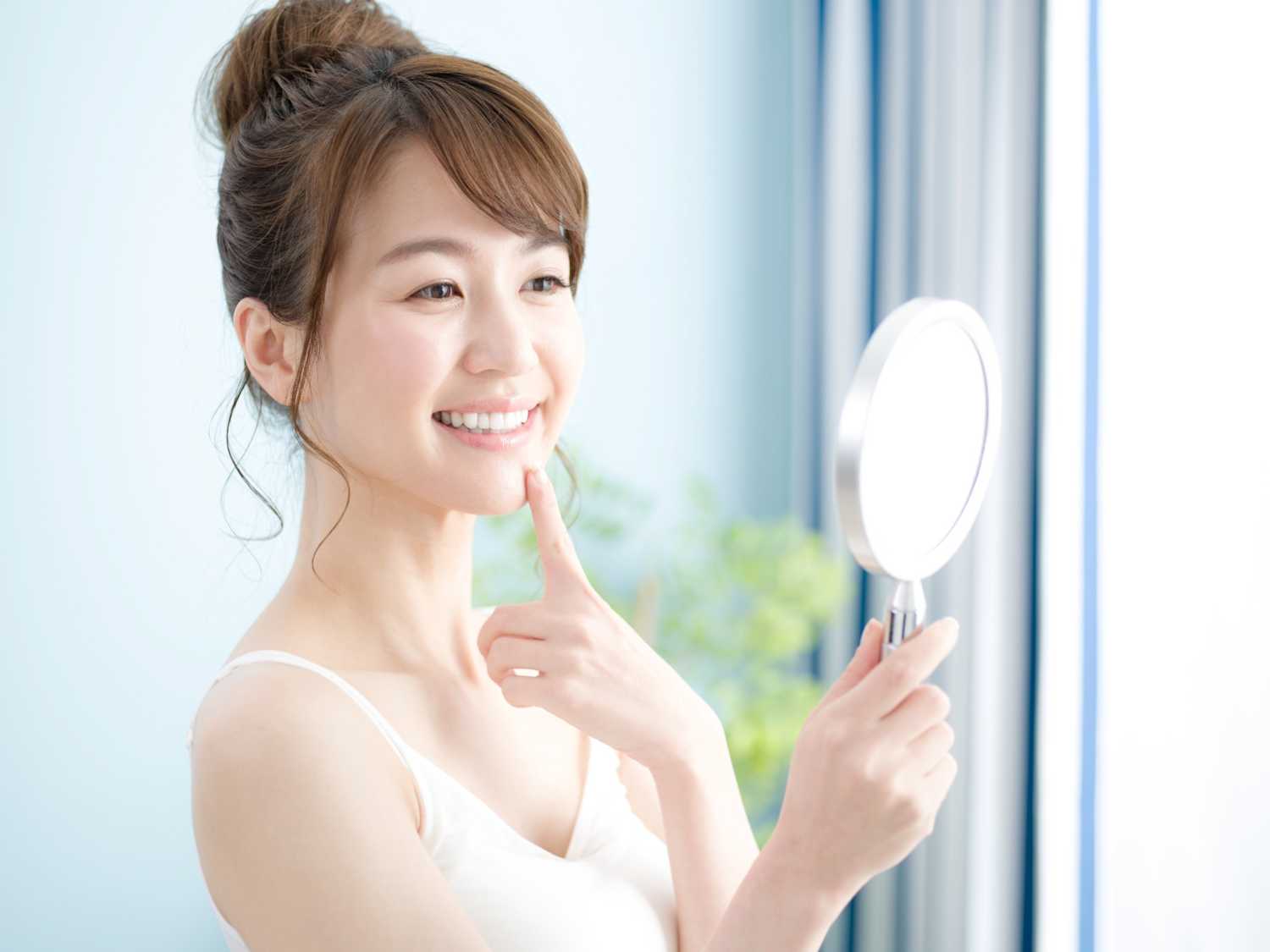 Adobe Stockの有料画像「手鏡を見る20代日本人女性」