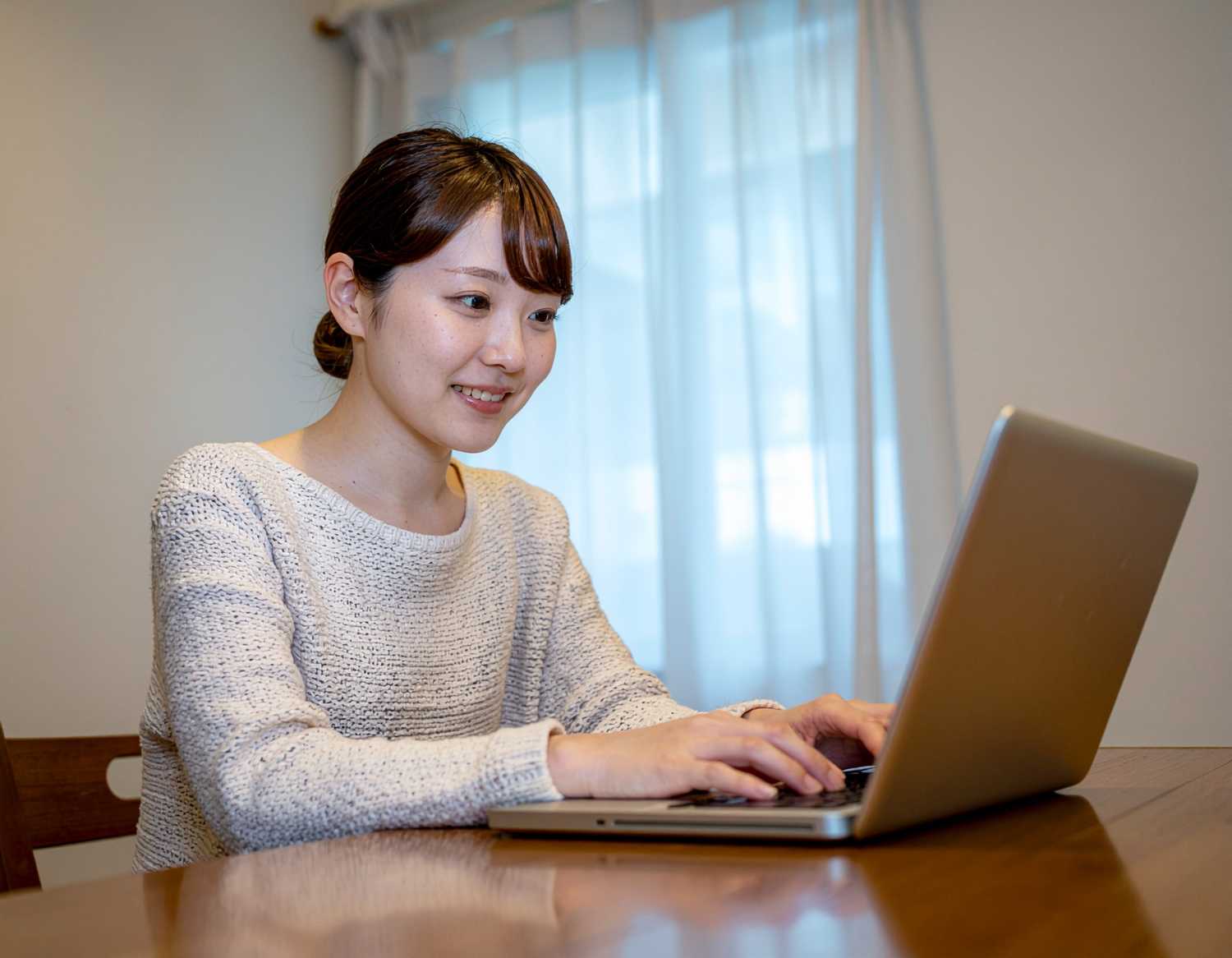 Image4で「パソコンをする20代の日本人女性。明るいイメージ。」というプロンプトで出力した画像イメージ